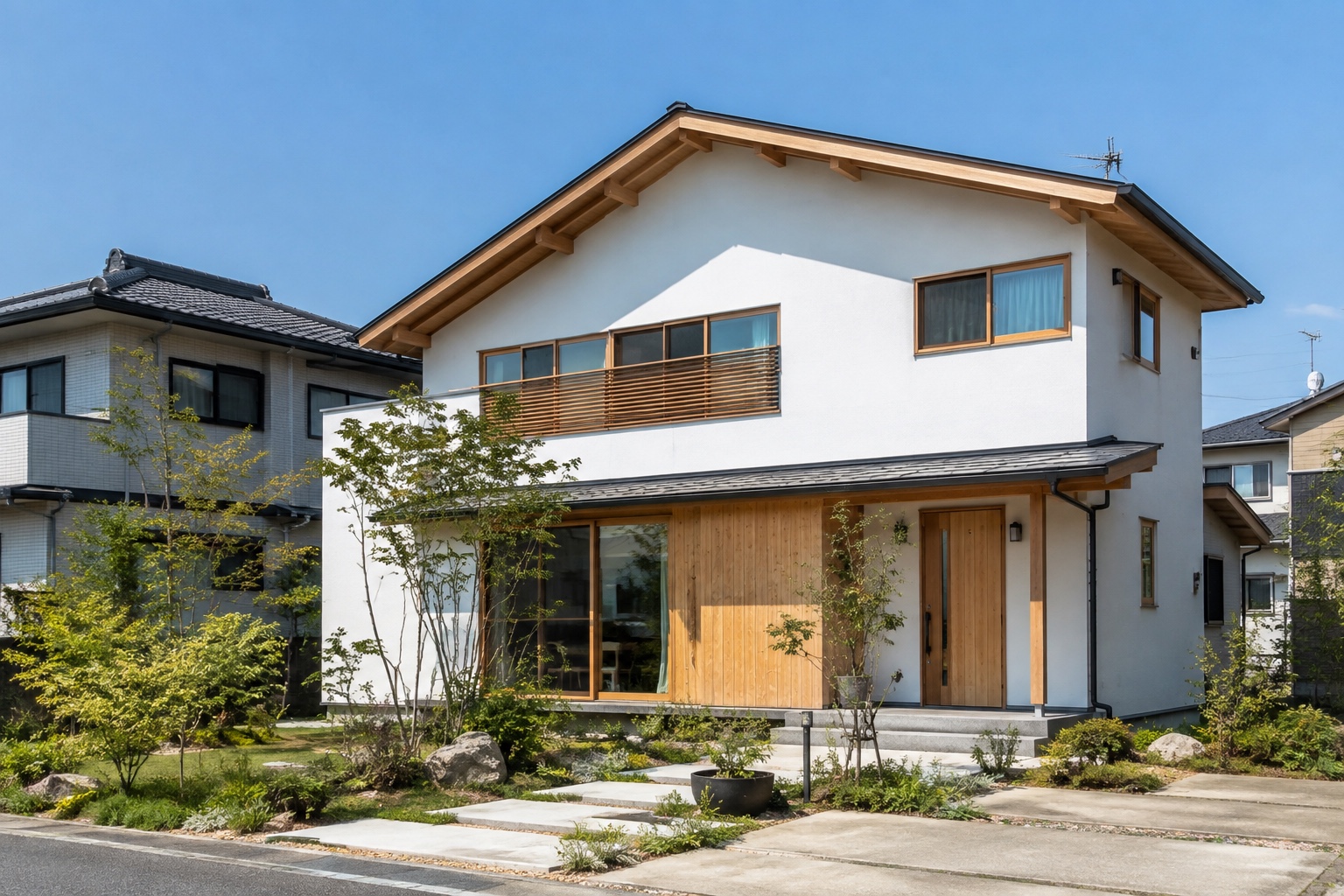 白い外壁と木のアクセントがある新築住宅